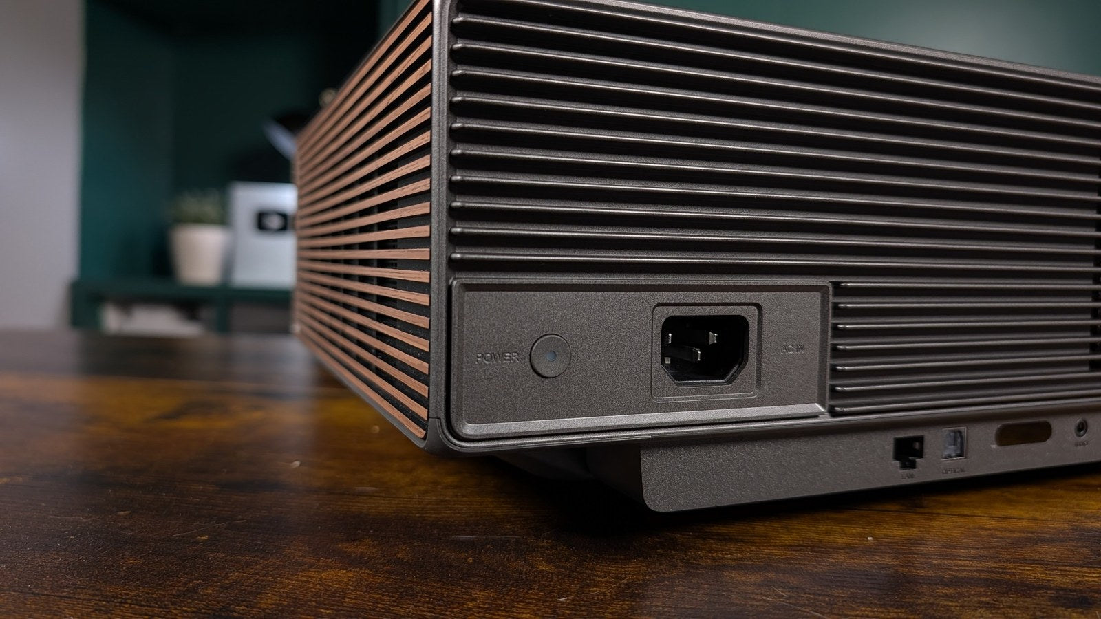 Rear corner of the XGIMI Aura 3 Max showing the physical power button and AC power inlet